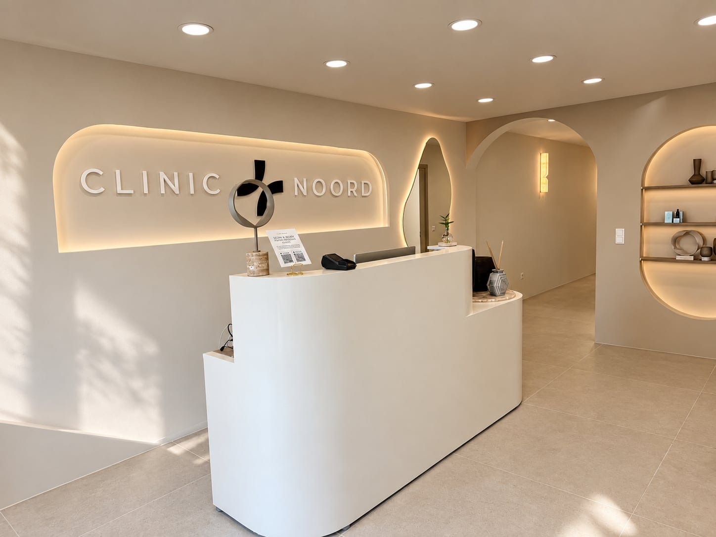 De balie van Clinic Noord met het verlichte logo aan de wand, in de zon